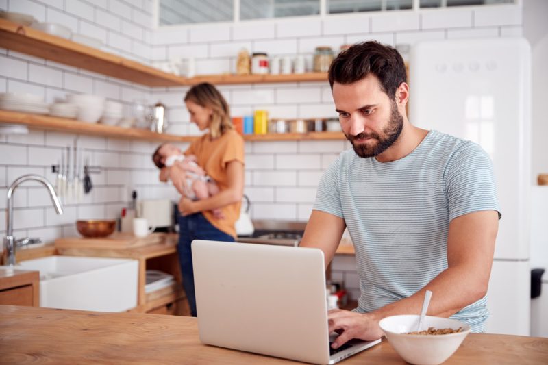 Couple with Baby in a Kitchen and Laptop