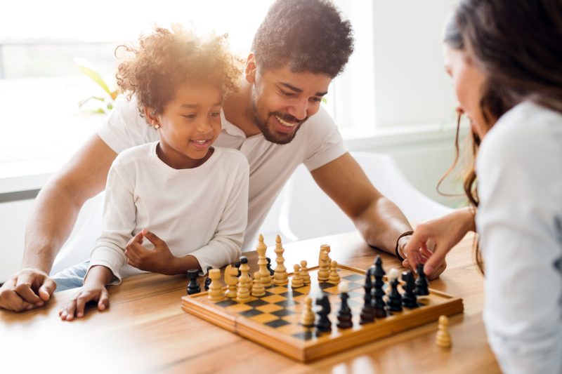 Father, Daughter and Mother Playing Chess