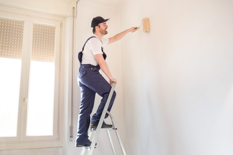 Man with Stairs Painting a Wall