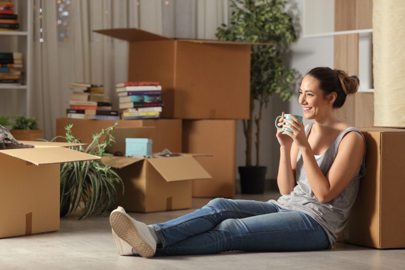 Happy Woman Moving In with Boxes