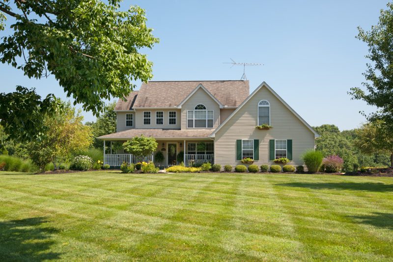 American Beige House with Threes in a Yard