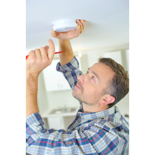 Home Owner Placing a Fire Alarm