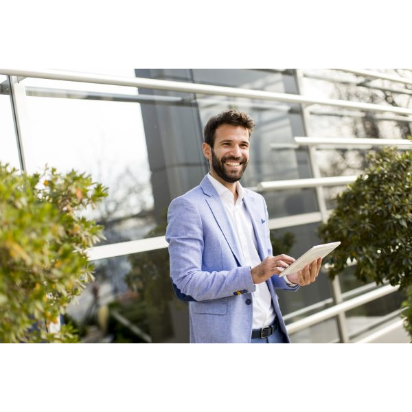 Smiling Man in Open Space with Tablet