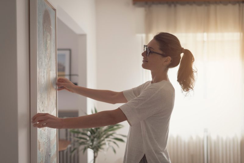 Woman Hanging a Frame