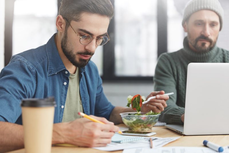 Young Man Having Lunch and Working